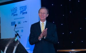 Mike stands clapping on stage at the Loo of The Year awards 2019.