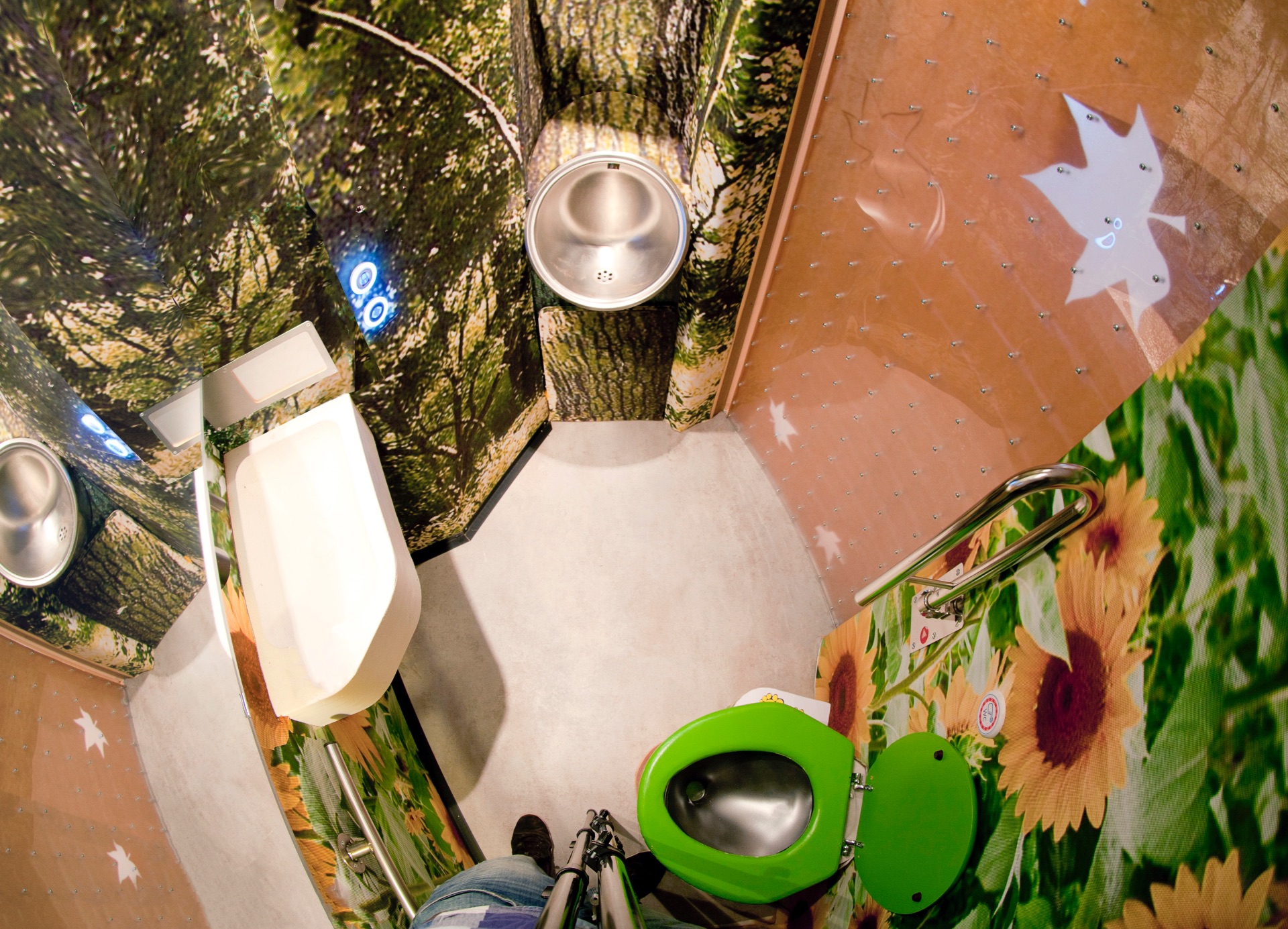 Automatic accessible train toilet with wall super-graphics of trees and flowers