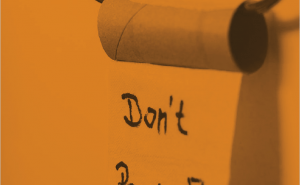 Image of Front page of Guide, orange background, toilet roll with 'Don't Panic' written on the last piece